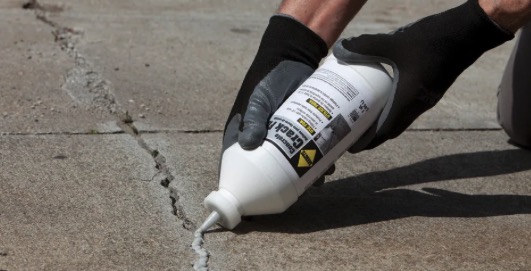 Worker repairing concrete surface with trowel in Virginia